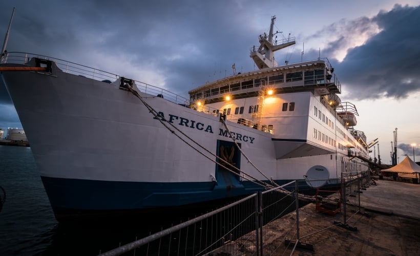 The Africa Mercy as the sun sets over the port of Cotonou, Benin 2017. Photo: Mercy Ships.